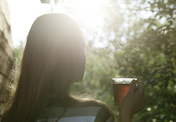 Image showing Woman with cup of tea in evening sunlight