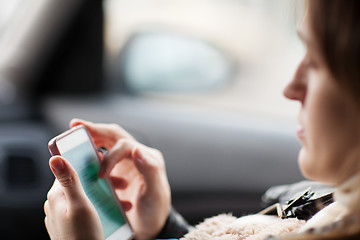 Image showing Woman uses smartphone in the car