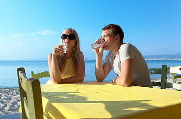 Image showing Young couple enjoying drinks at the seaside