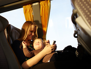 Image showing Mother and kid are playing game on the phone.