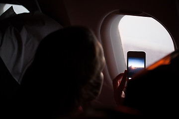 Image showing Woman taking photographs through a cabin porthole