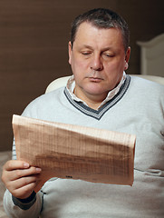 Image showing Portrait of senior man reading newspaper at home.