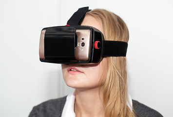 Image showing Woman wearing VR-headset over white background