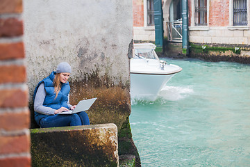 Image showing Young woman using laptop by the canal in Venice