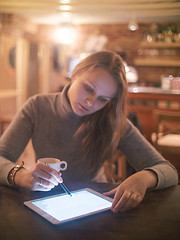 Image showing Woman with Tablet PC and Stylus in Cafe