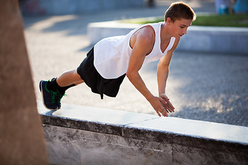 Image showing Teenager performing push-ups outdoor in city