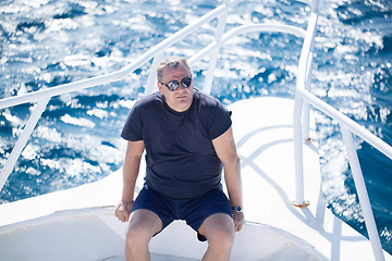 Image showing Man sitting on the prow of a boat