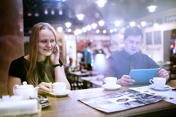 Image showing Woman on cellphone drinking coffee