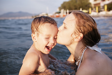 Image showing Mother kissing her young child