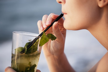 Image showing Close up of woman enjoying an evening cocktail