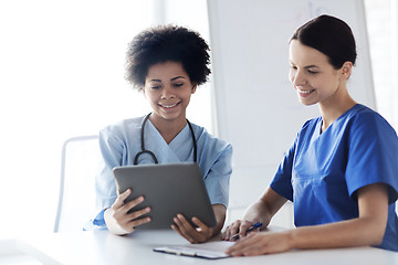 Image showing happy doctors with tablet pc meeting at hospital