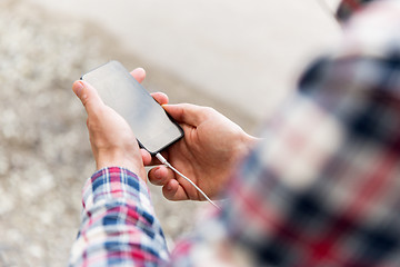 Image showing close up of male hands with smartphone on street