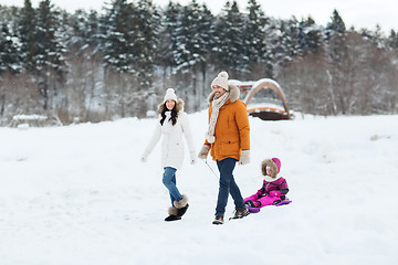 Image showing happy family with sled walking in winter forest