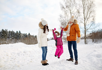 Image showing happy family in winter clothes walking outdoors