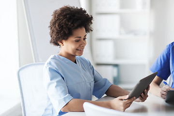 Image showing happy female doctor or nurse with tablet pc