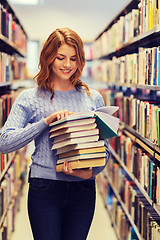 Image showing happy student girl or woman with books in library