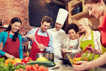 Image showing happy friends and chef cook cooking in kitchen