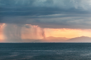 Image showing Rain clouds in distant plains near mountains