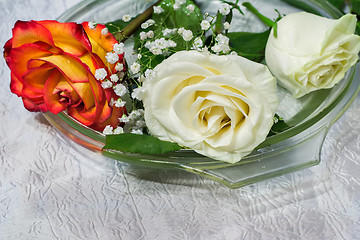 Image showing The roses on the table on a glass dish.