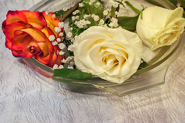 Image showing The roses on the table on a glass dish.