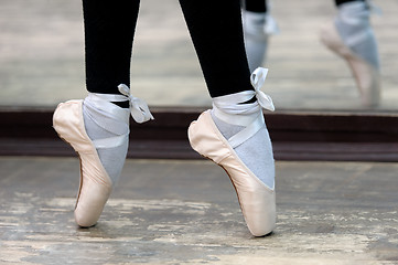 Image showing Close up view to ballerinas legs in pointes on wooden floor