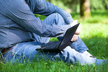 Image showing Detail of hands and laptop keyboard.