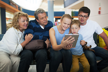 Image showing Big family entertaining with touch pad at the airport