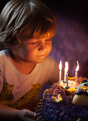 Image showing Little boy blows out candles on his birthday