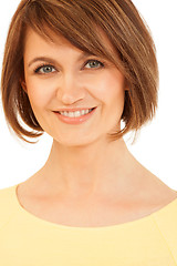 Image showing Adult brunette in yellow smiling at camera