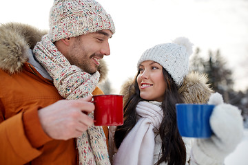 Image showing happy couple with tea cups over winter landscape