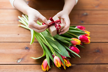 Image showing close up of woman with gift box and tulip flowers