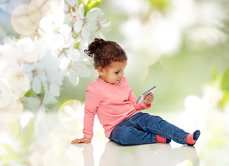 Image showing smiling little baby girl playing with smartphone