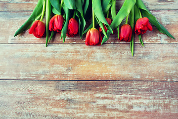 Image showing close up of red tulips on wooden background