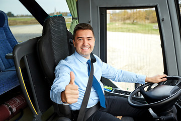 Image showing happy driver driving bus and snowing thumbs up