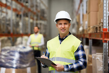 Image showing man with clipboard in safety vest at warehouse