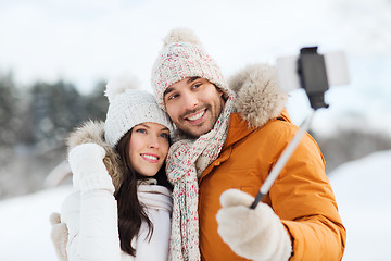 Image showing happy couple taking selfie by smartphone in winter