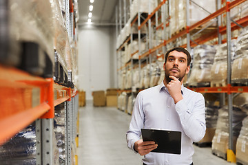 Image showing businessman with clipboard at warehouse