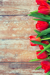 Image showing close up of red tulips on wooden background