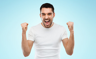 Image showing young man celebrating victory blue gray