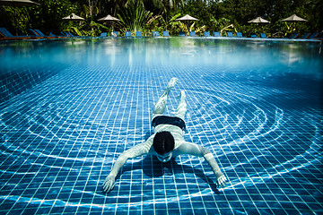 Image showing Man floats underwater in pool