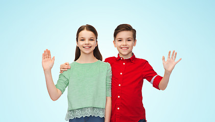 Image showing happy boy and girl waving hand