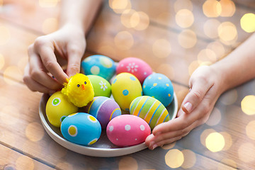 Image showing close up of woman hands with colored easter eggs