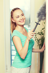 Image showing happy woman with duster cleaning at home
