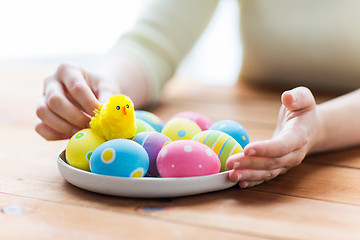 Image showing close up of woman hands with colored easter eggs