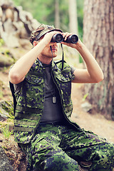 Image showing young soldier or hunter with binocular in forest