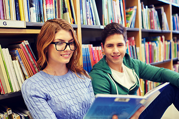 Image showing close up of happy students reading book in library