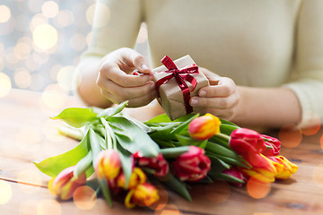 Image showing close up of woman with gift box and tulip flowers