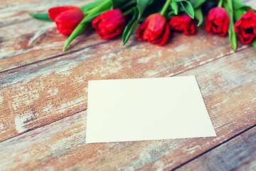 Image showing close up of red tulips and blank paper or letter