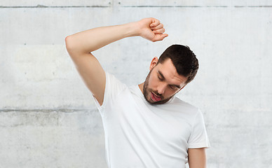 Image showing young making gallows gesture over gray wall