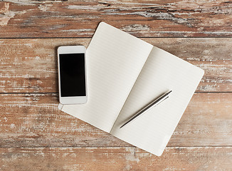 Image showing close up of notebook, pen and smartphone